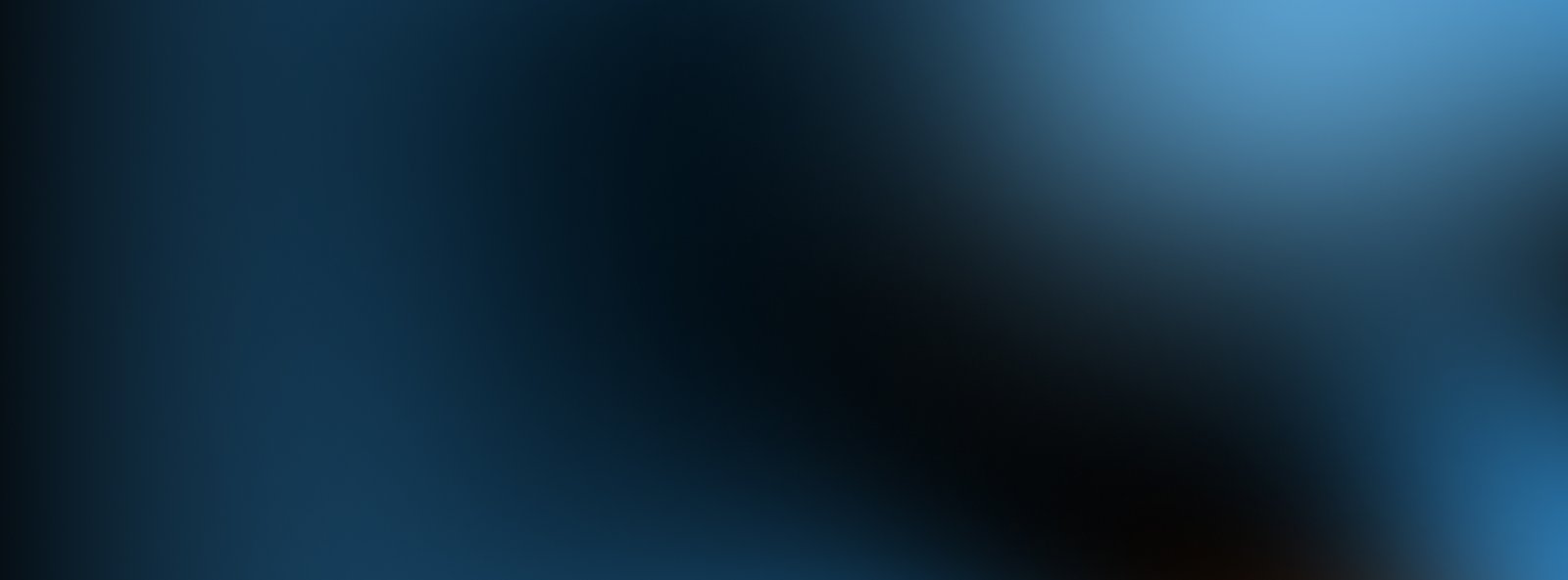 A blurred image with shades of blue and black blending together, creating an abstract and smooth gradient effect.